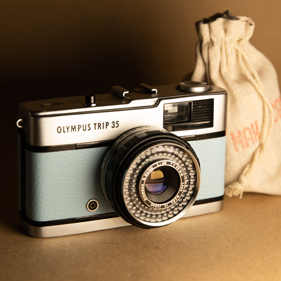 Baby Blue Olympus Trip 35mm film camera with roll of film
