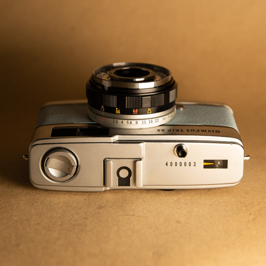 Baby Blue Olympus Trip 35mm film camera with roll of film