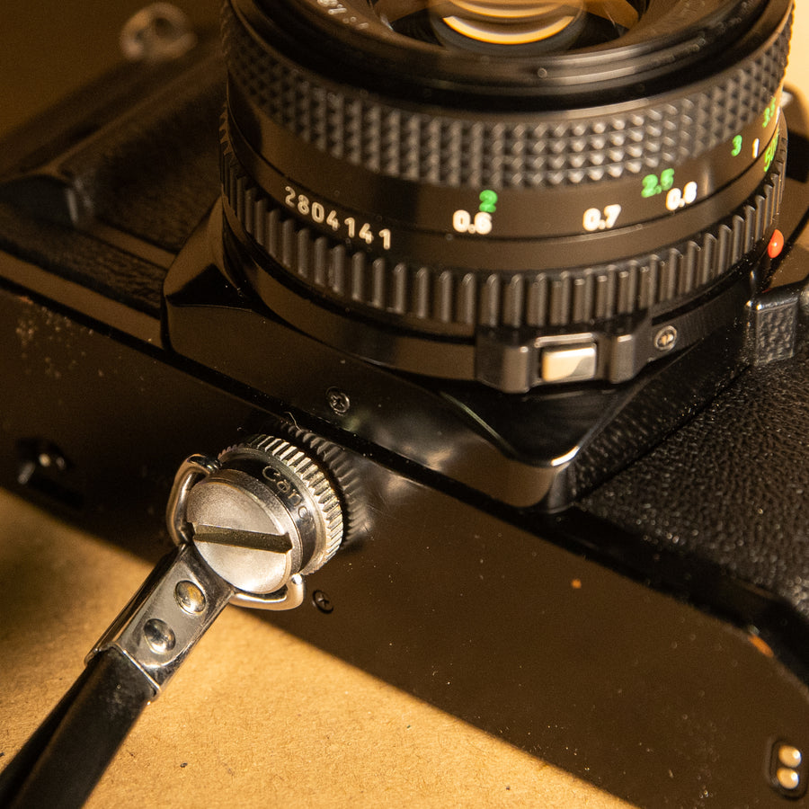 Canon wrist strap screws into tripod mount for 35mm film cameras