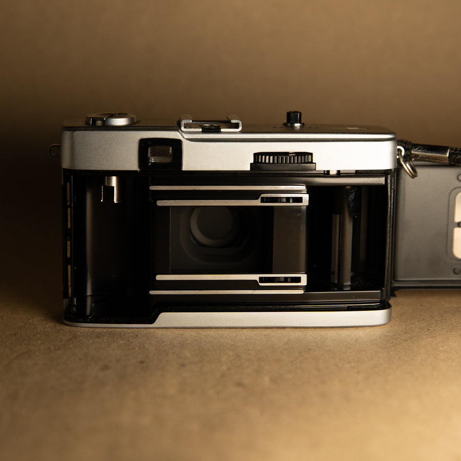 Burgundy Olympus Trip 35mm film camera with roll of film
